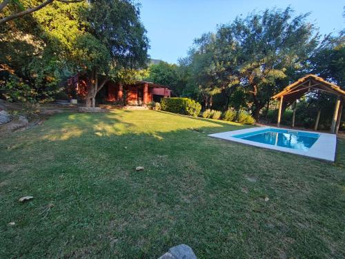 a backyard with a swimming pool in the grass at TADASANA CASA DE CAMPO in La Carrera