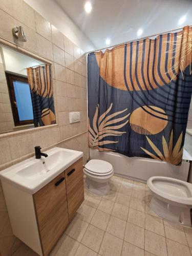 a bathroom with a sink and a toilet and a shower curtain at Moonlight Apartment in Fiumicino