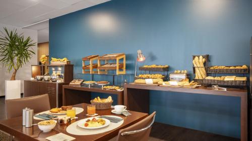 un restaurant avec une table avec de la nourriture dessus dans l'établissement Residhome Suites Paris Sénart, à Lieusaint