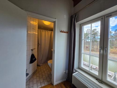 a bathroom with a shower and a toilet and a window at Norrqvarn Hotel & Resort by Vänerport in Lyrestad