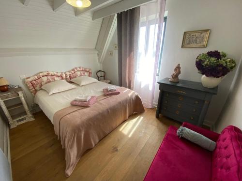 Un dormitorio con una cama grande con una manta rosa. en Les Monts d'Amara, ressourcement, nature, santé, en Campuac