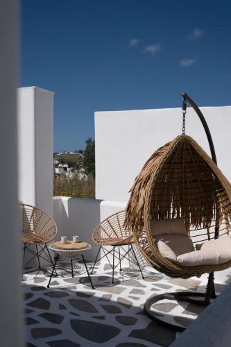 a patio with two chairs and a swing at Paridian Elegant Living in Parikia