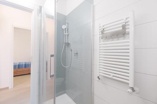 un bagno con doccia con porta in vetro di Riotorto - Appartamento con terrazzo vista mare e giardino a Riotorto
