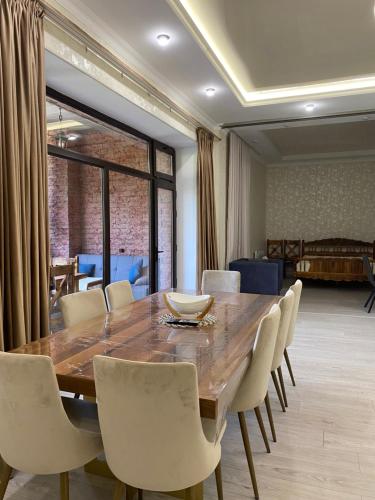 a dining room with a large wooden table and chairs at Dom Adonis in Dilijan