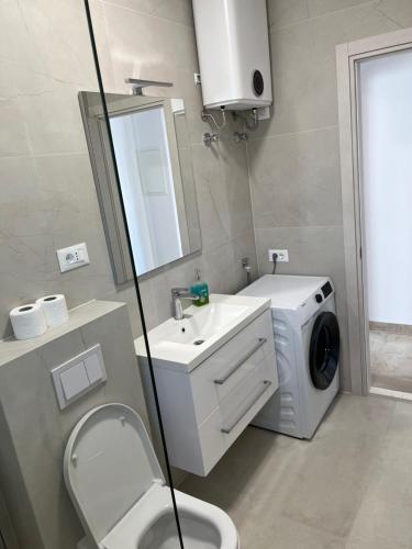 a bathroom with a washing machine and a washer at Apartman Sobin 1 in Kaštela