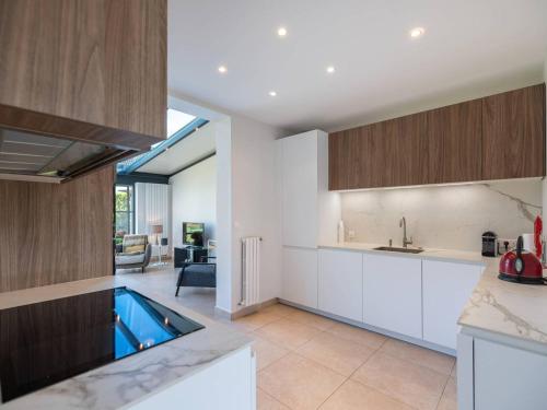 une cuisine avec des placards blancs et une piscine. dans l'établissement Maison spacieuse avec Wi-Fi et parking, proche plage - FR-1-821-16, à Le Touquet-Paris-Plage