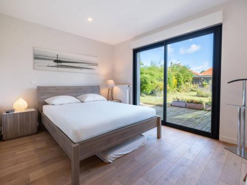 une chambre avec un lit et une grande fenêtre dans l'établissement Maison spacieuse avec Wi-Fi et parking, proche plage - FR-1-821-16, à Le Touquet-Paris-Plage
