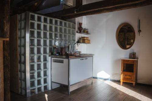 une cuisine avec un comptoir et un mur avec des carrés de verre dans l'établissement Gîtes Domaine Bonneblond, à Saint-Désiré