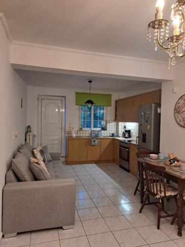 a living room and kitchen with a couch and a table at Sweet Green Home in Nea Makri in Nea Makri