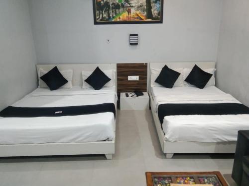 a room with two beds and a picture on the wall at Hotel S R in Lucknow