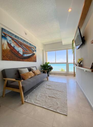 a living room with a couch and a tv at Ocean View. Acogedor Apartamento frente al mar in Porlamar