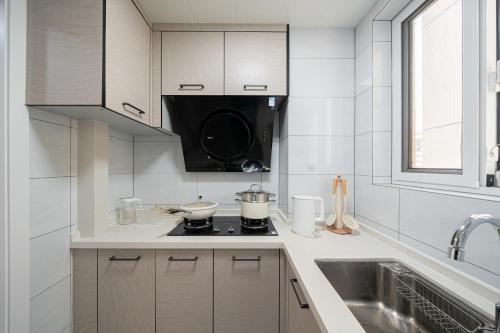 a white kitchen with a stove and a sink at Today Aparthotel West Lujiazui Shanghai in Shanghai