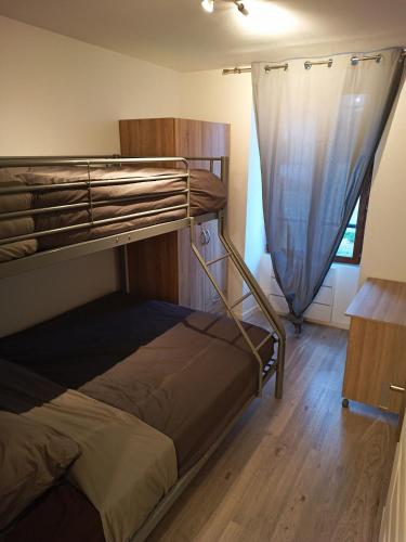une chambre avec un lit superposé et une fenêtre dans l'établissement Maison 5 Pers proche Disney, à La Houssaye-en-Brie