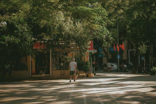 a man walking down a street at The Bloom Hanoi - Bespoke Living in Hanoi