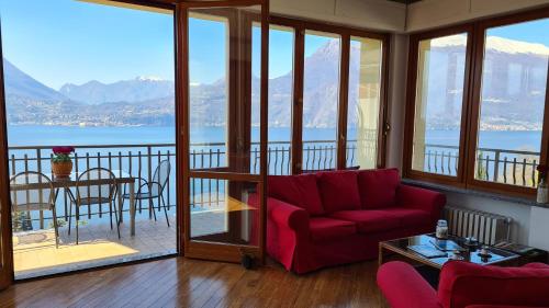 a living room with a red couch and a table at Villa gli Ulivi - Bariloche Lake & Mountain View in Perledo