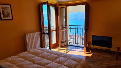 a bedroom with a balcony with a view of the ocean at Villa gli Ulivi - Bariloche Lake & Mountain View in Perledo