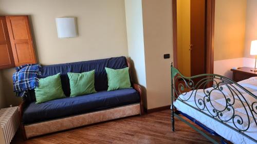 a blue couch with green pillows in a room at Villa gli Ulivi - Bariloche Lake & Mountain View in Perledo