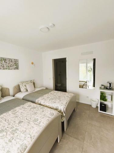 a bedroom with two beds and a window at FlorAL in Aljezur