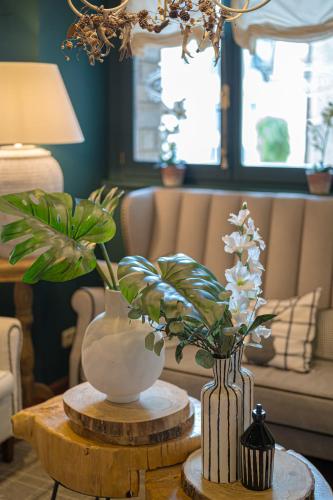 a living room with a table with a vase and flowers at Hotel El Ciervo in Vielha