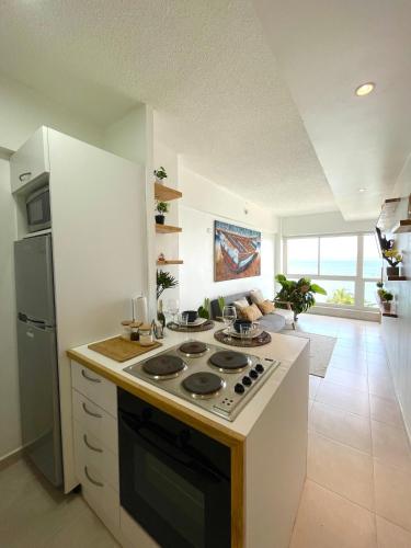 a kitchen with a stove top oven in a room at Ocean View. Acogedor Apartamento frente al mar in Porlamar