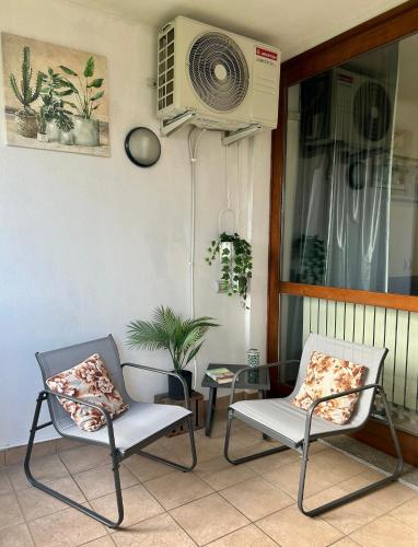 a porch with two chairs and a heater and a table at Terrazza Nutshell Parco, Centro, Policlinico in Monza