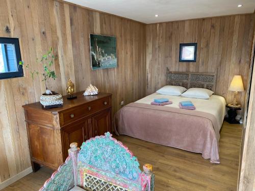 a bedroom with a bed and a chair in it at Les Monts d'Amara, ressourcement, nature, santé in Campuac