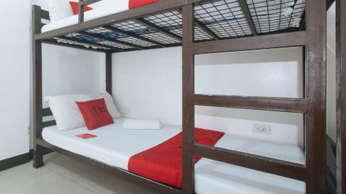 a bedroom with a bunk bed with a red pillow at Rielena Plaza Hotel and Suites in Molave