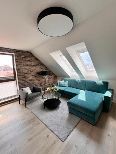 a living room with a blue couch and a table at Stay in Trnava in Trnava