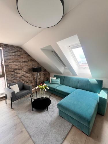 a living room with a blue couch and a brick wall at Stay in Trnava in Trnava