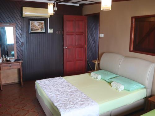 a bedroom with a bed with a red door at Tioman Beruntun Hideaway in Tioman Island
