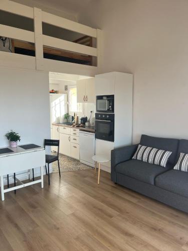 un salon avec un canapé et une table et une cuisine dans l'établissement Bulle Marine, à Bandol