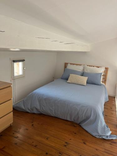 une chambre avec un grand lit avec des oreillers bleus dans l'établissement Bulle Marine, à Bandol