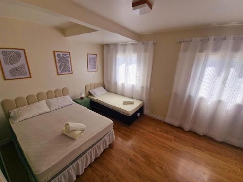 ein Schlafzimmer mit einem Bett und einem Tisch und einem Fenster in der Unterkunft Melhor cervejaria do Brasil e a Serra te esperam! in Orleans