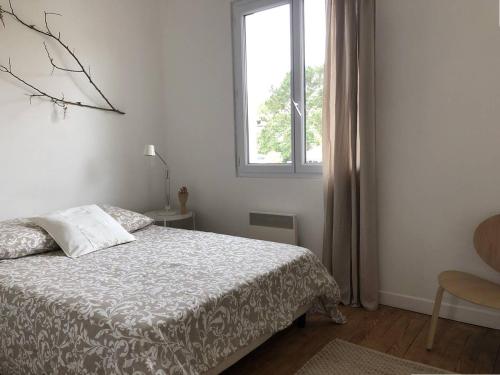 une chambre blanche avec un lit et une fenêtre dans l'établissement PASTEUR 1 - Appartement pour 4 au centre ville d'Hossegor, à Soorts-Hossegor