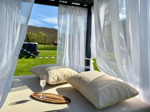 a table with two pillows and a wine glass at Aqua Vita Concept in Bihać