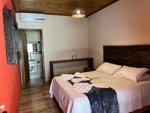 a bedroom with a bed with towels on it at Pousada Flor de Pequi in Serra do Cipo