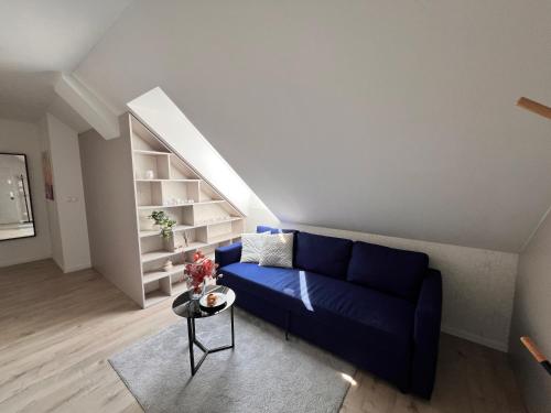 a living room with a blue couch and a table at Stay in Trnava in Trnava