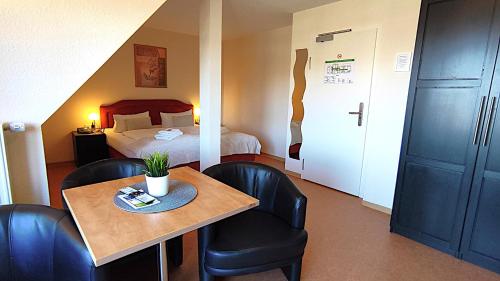 a hotel room with a bed and a table and chairs at Ostseehotel Rike in Wismar