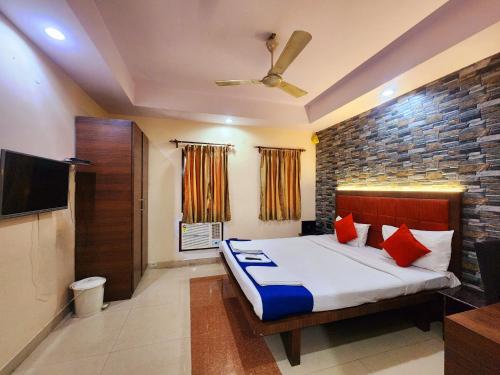 a bedroom with a bed and a flat screen tv at Bhammar's Inn - A Pure Veg in Kolkata