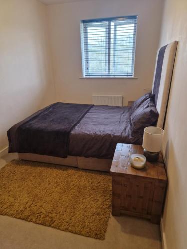 a bedroom with a bed and a table and a window at Lovely and Cosy Double Room in Havering atte Bower