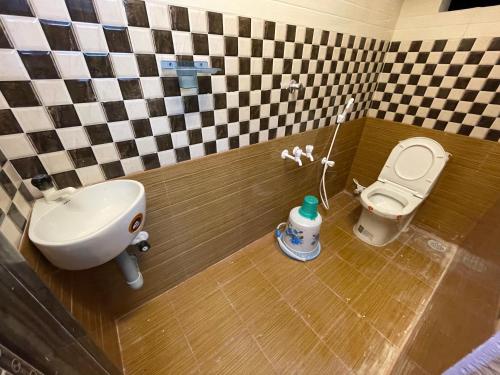 a bathroom with a white toilet and a sink at Sri Lakshmi Family Guest House in Vadalūr