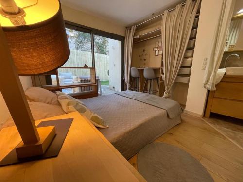 une chambre avec un lit et une table avec une lampe dans l'établissement Glass and wood designer villa with garden in centertown, à Montpellier