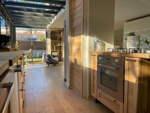 une cuisine avec un évier et une cuisinière dans l'établissement Glass and wood designer villa with garden in centertown, à Montpellier