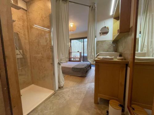 Cette chambre comprend un lit et une salle de bains pourvue d'une douche. dans l'établissement Glass and wood designer villa with garden in centertown, à Montpellier