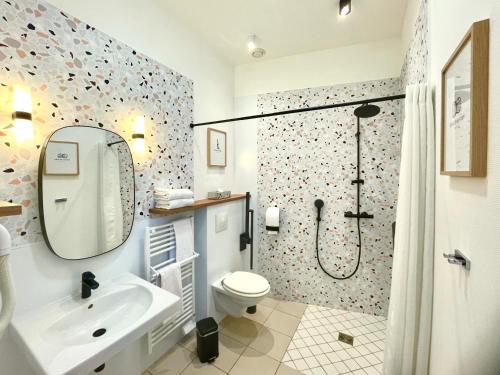 a bathroom with a shower and a toilet and a sink at Logis Hôtels- Hôtel Marguerite d'Anjou Angers château in Angers