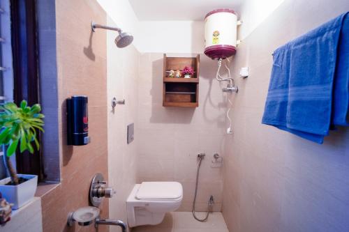 a small bathroom with a toilet and a shower at Woodburry Mansion, Cozy Nainital Homestay in Nainital