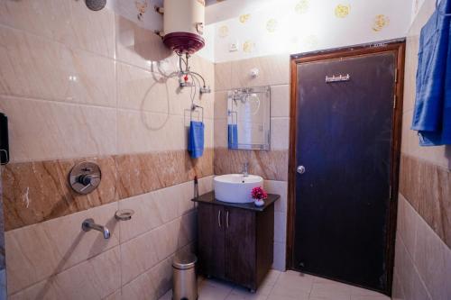 a bathroom with a sink and a blue door at Woodburry Mansion, Cozy Nainital Homestay in Nainital