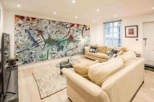 a living room with a large painting on the wall at -Air Con- 3BD Mews House - Kensington Palace! in London