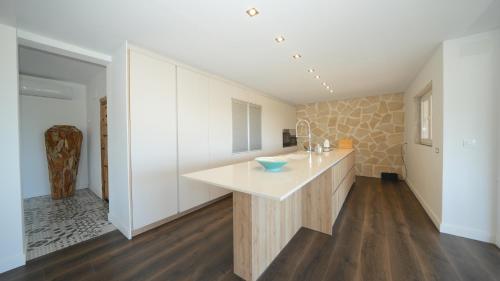 FontillesにあるVilla Aguilaの- ウッドフロアのキッチン(白いカウンター付)