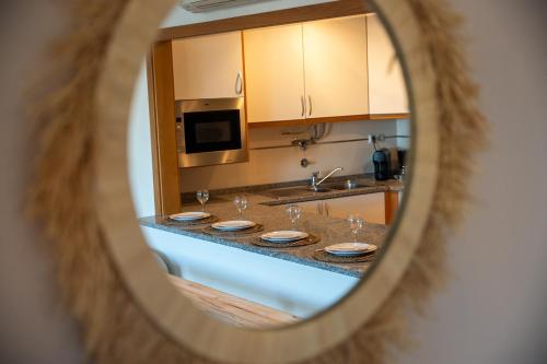 a mirror reflecting a kitchen counter with glasses on it at Old Town Boho Seaview Elegance in Albufeira
